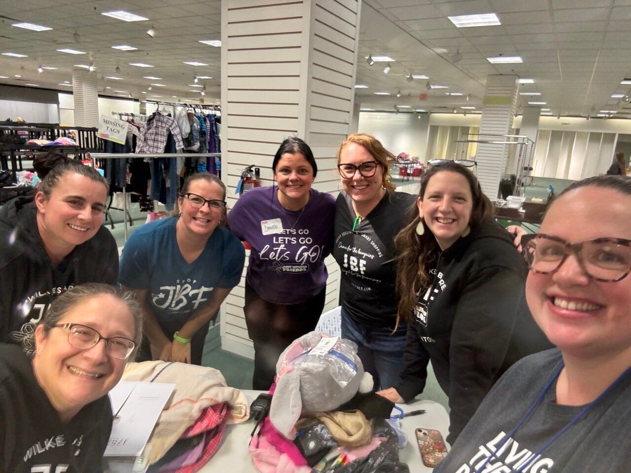 A cashier smiles behind her mask as she gets ready to check out the next happy JBF customer.